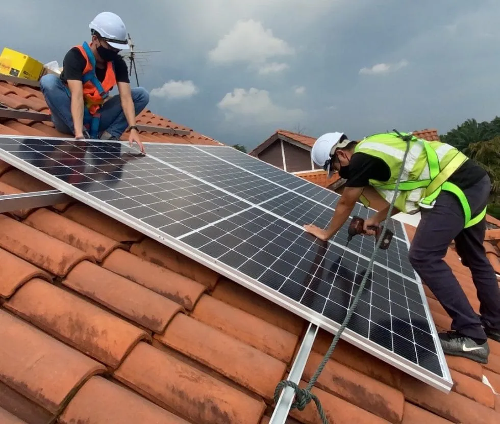 Solar installers fitting panels on a roof